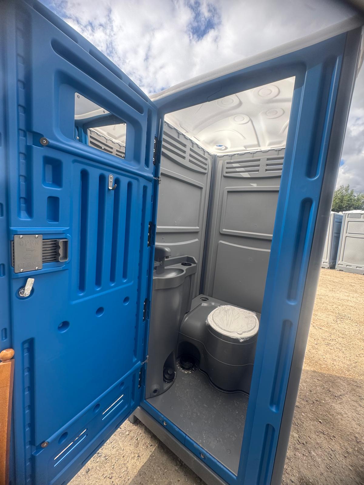 Inside the portable toilet: toilet, hand basin and coat hook